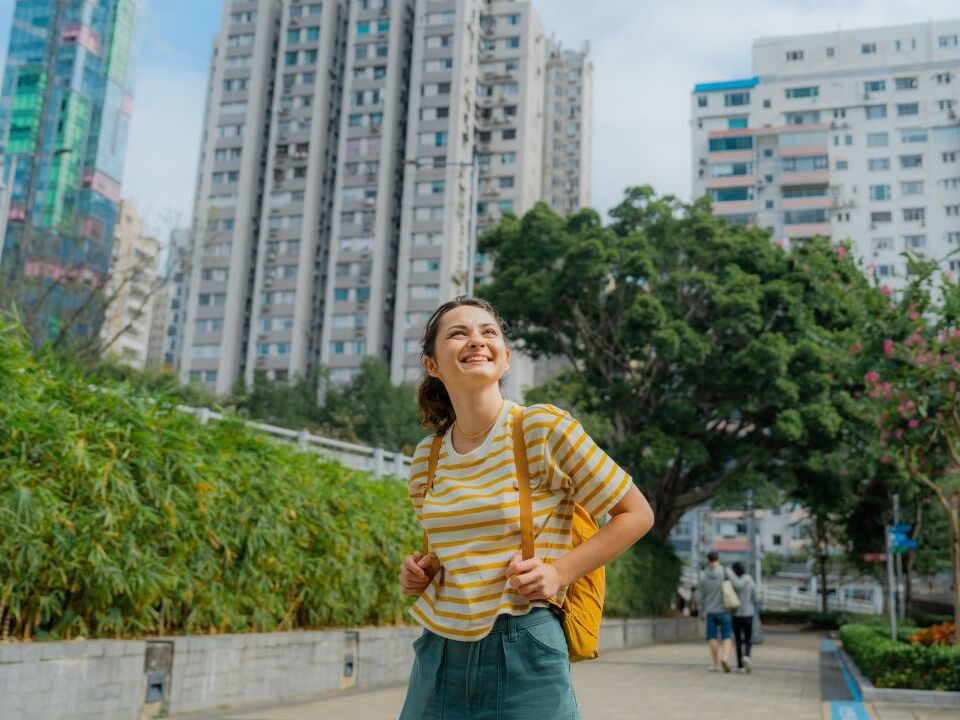 Woman smiling and walking through Victoria Park.