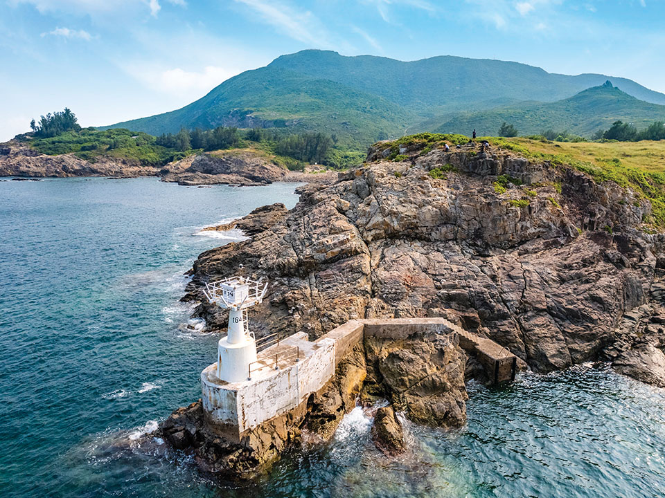 Tung Lung Chau lighthouse stands on barnacle-covered rocks