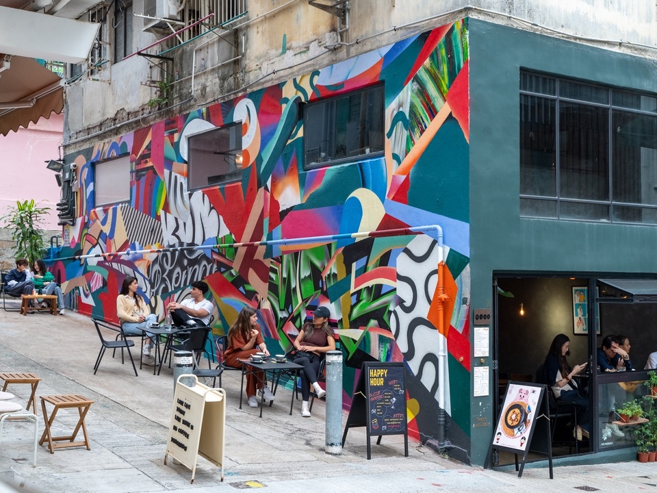 Side of a wall featuring a brightly coloured mural by Miguel Emerico on Tai Ping Shan Street. 
