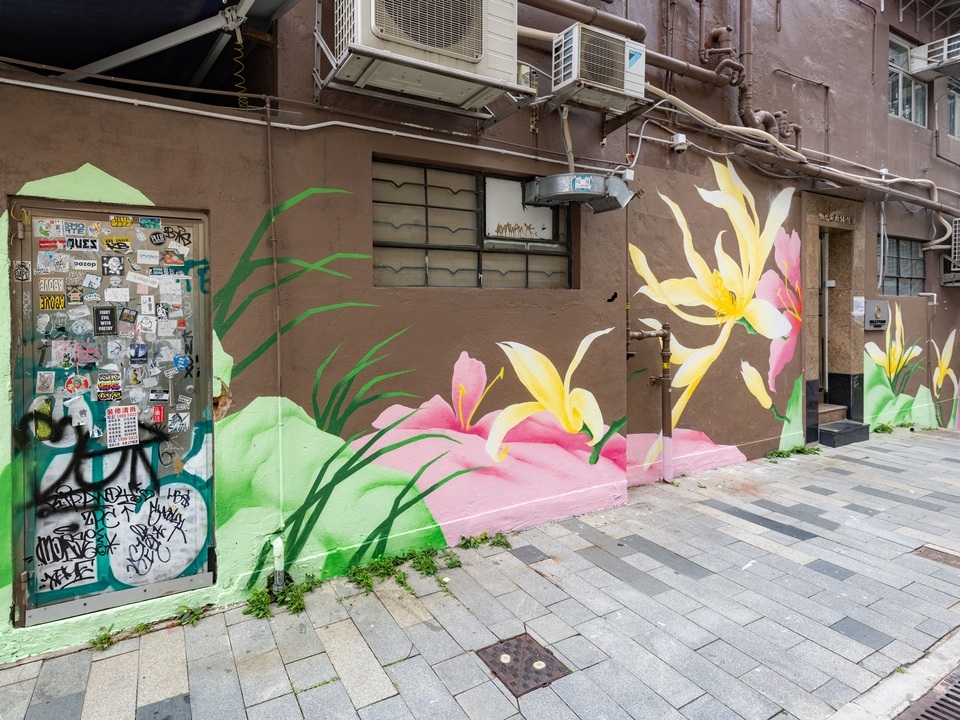 Street art of pink and yellow flowers by Zelam Lim. 