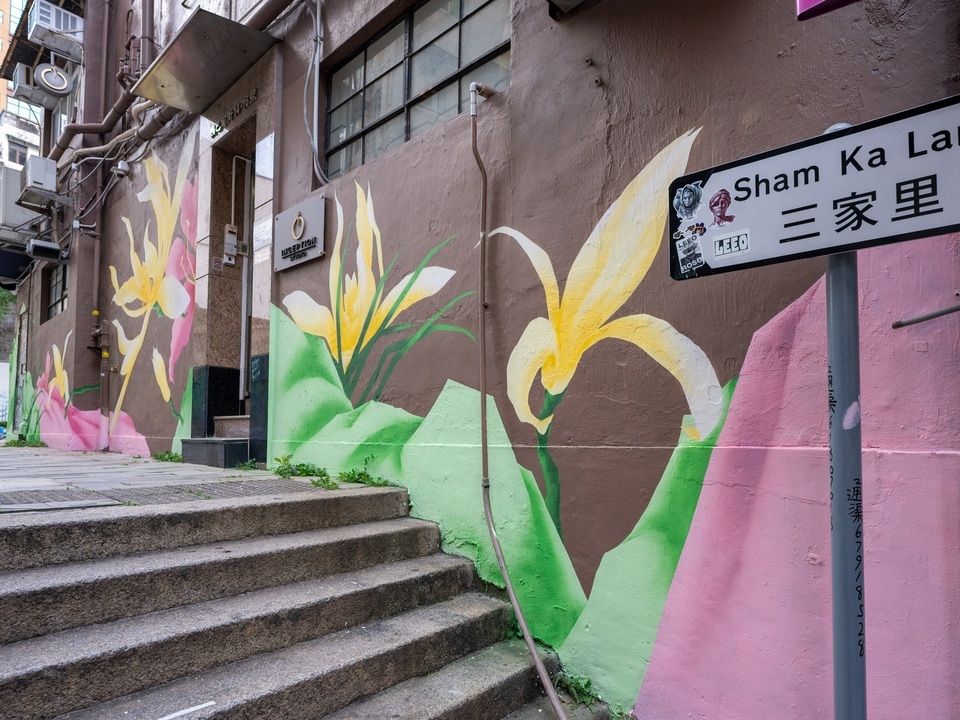 Street sign of Sham Ka Lane besides a mural of flowers by Zelam Lim. 