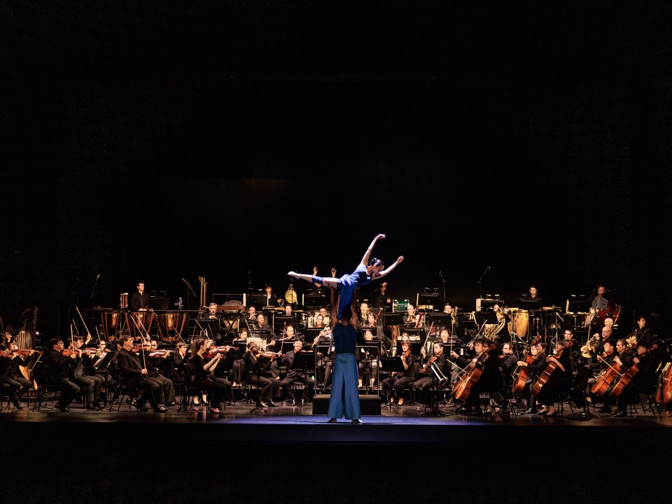 Dance performance amid a large orchestra for the French May Arts Festival
