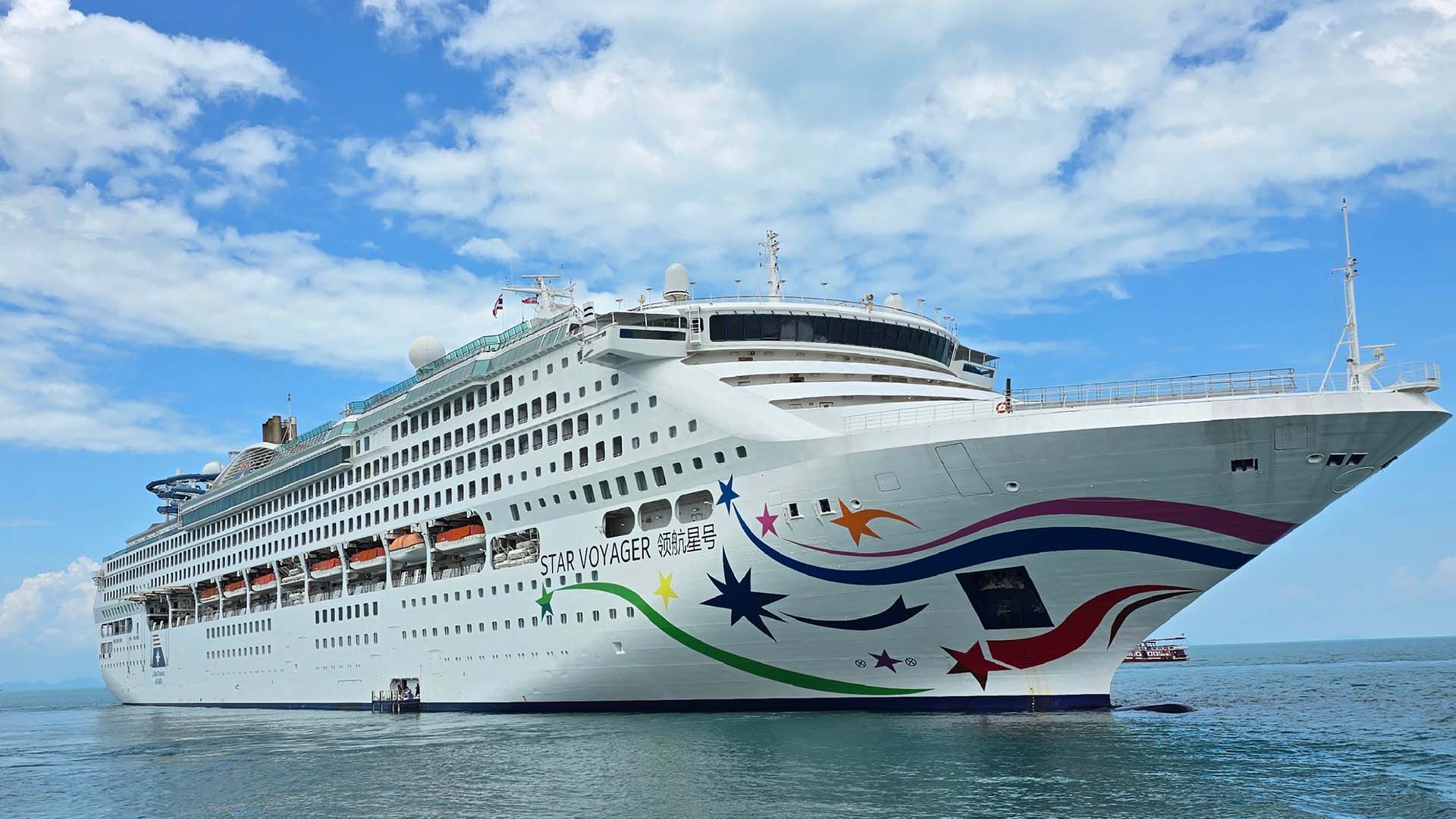 StarCruises’ Star Voyager on the seas with blue skies and white clouds.