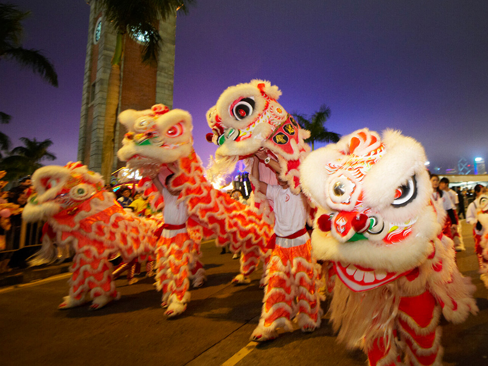 A lively and festive lion dance alongside the Clock Tower in Hong Kong