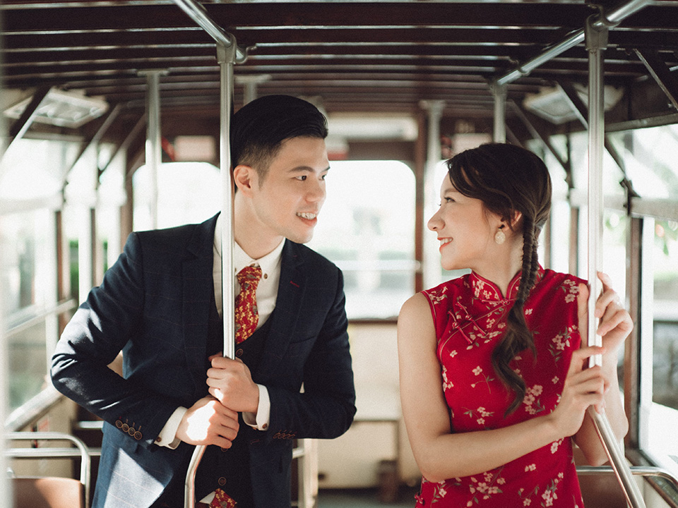 一對情侶在香港電車上層內深情對望。