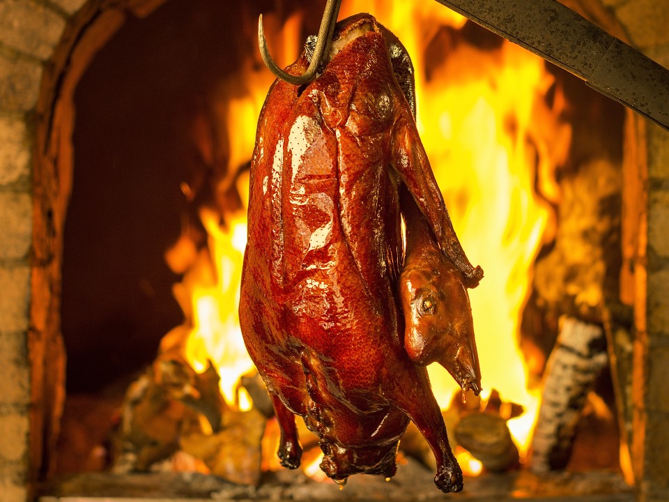 Roasted siu mei in front of a fire.