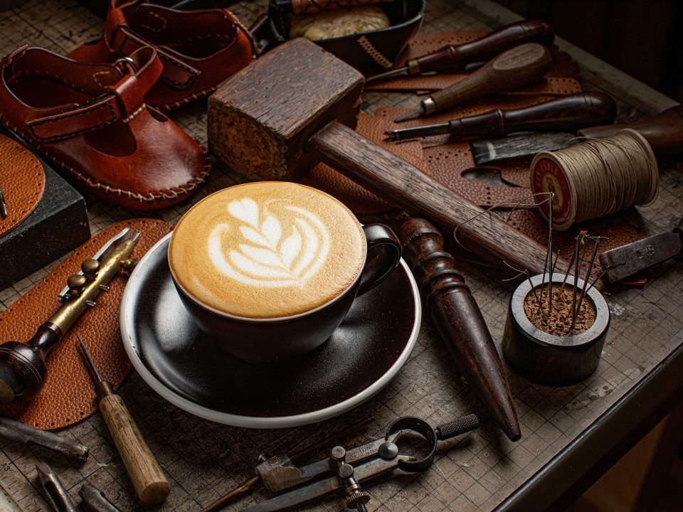A cup of coffee on a table of tools