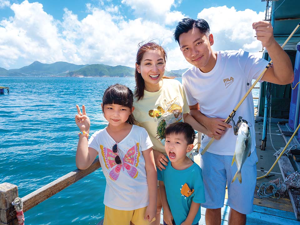 Angie Mak tận hưởng niềm vui bên gia đình trên bãi biển tại khiếu Tây Châu, nơi có đàn cá bơi lội vờn quanh bàn chân