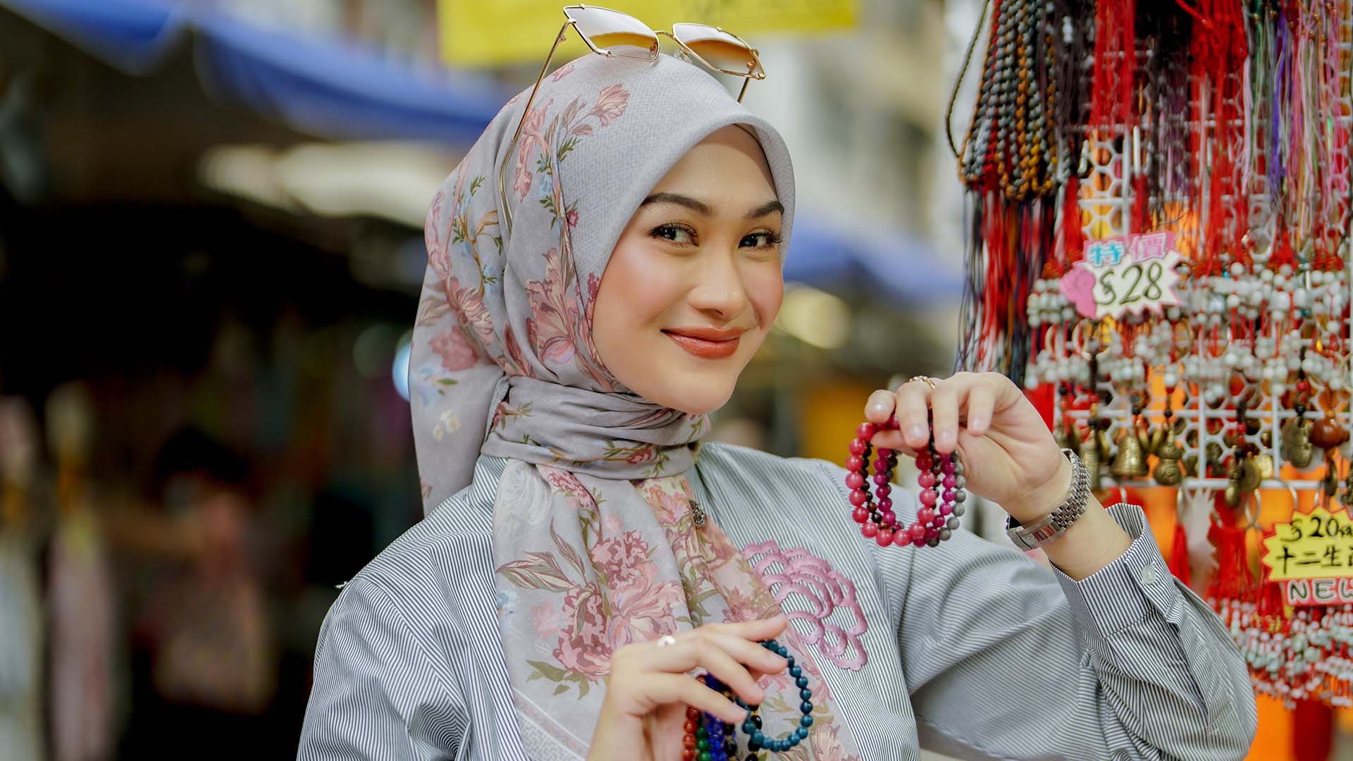 Indah Nada Puspita holding beaded jewellery at a market in Hong Kong. 