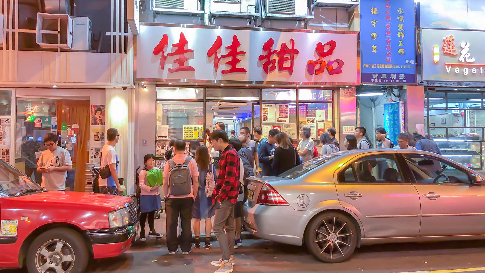 Late night crowd of people standing outside a popular dessert shop in Hong Kong