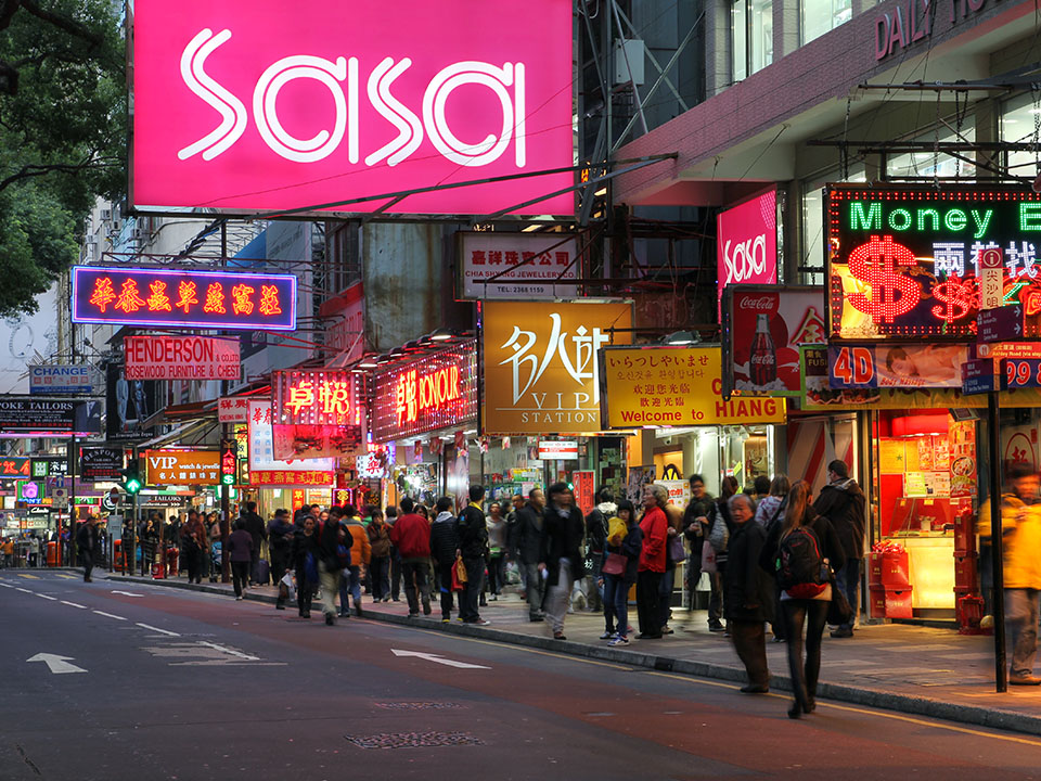 Lit up shop signs along a busy street in Tsim Sha Tsui
