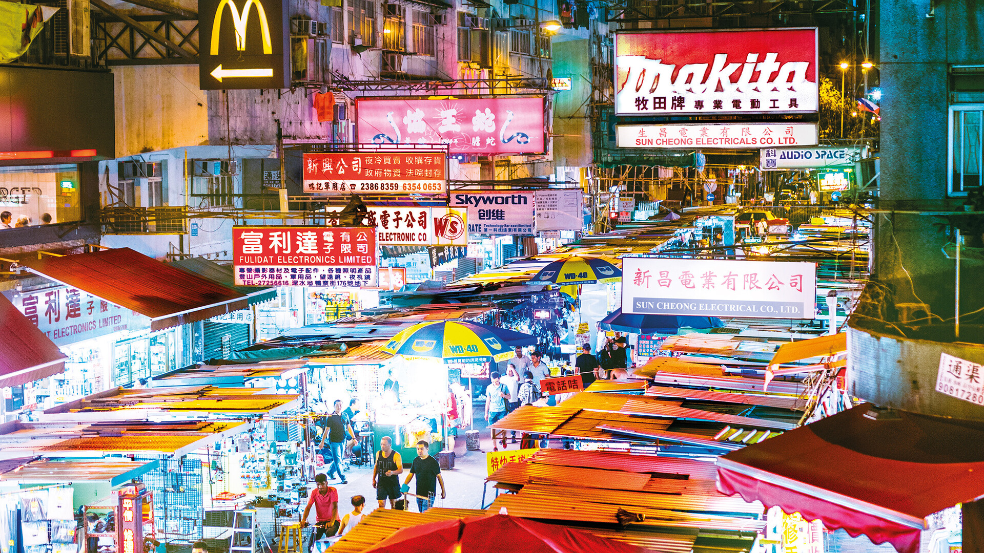Neon signs and market stalls in Hong Kong at night