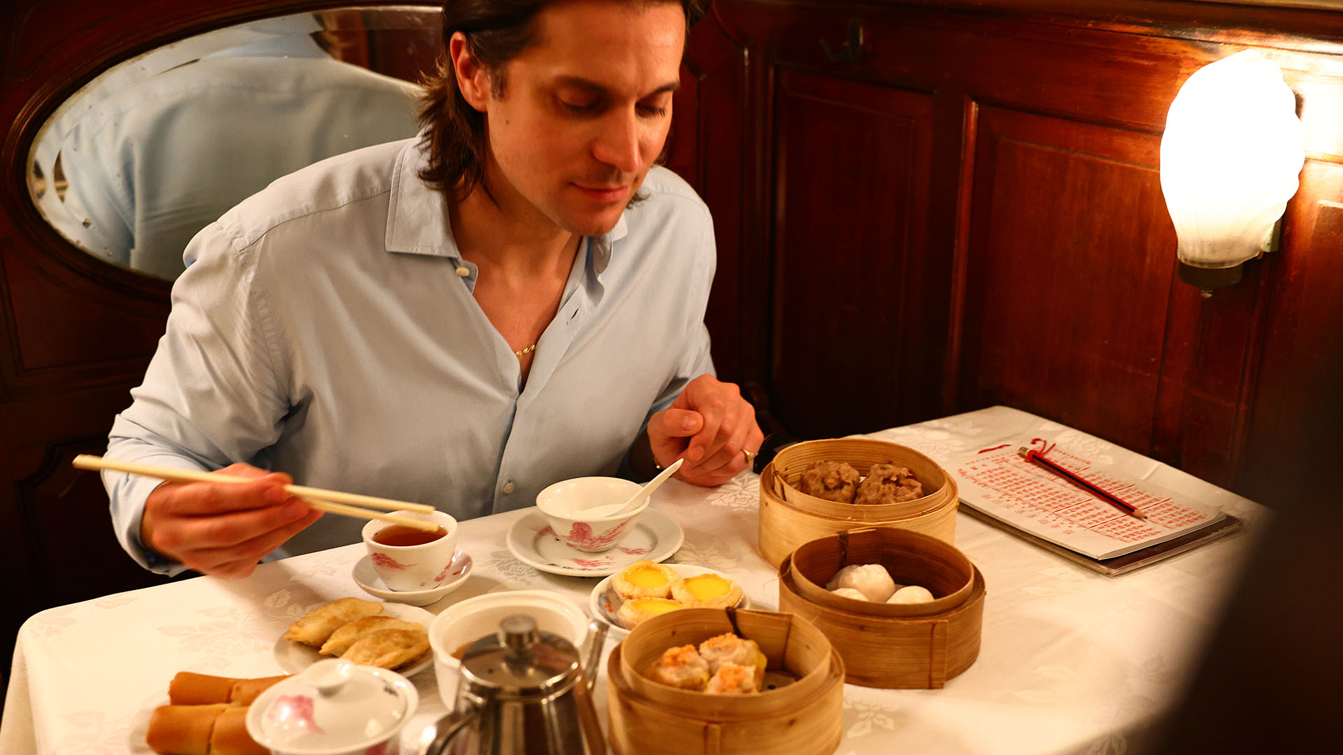 Lucas Bravo enjoying a dim sum meal at Luk Yu Teahouse in Hong Kong.