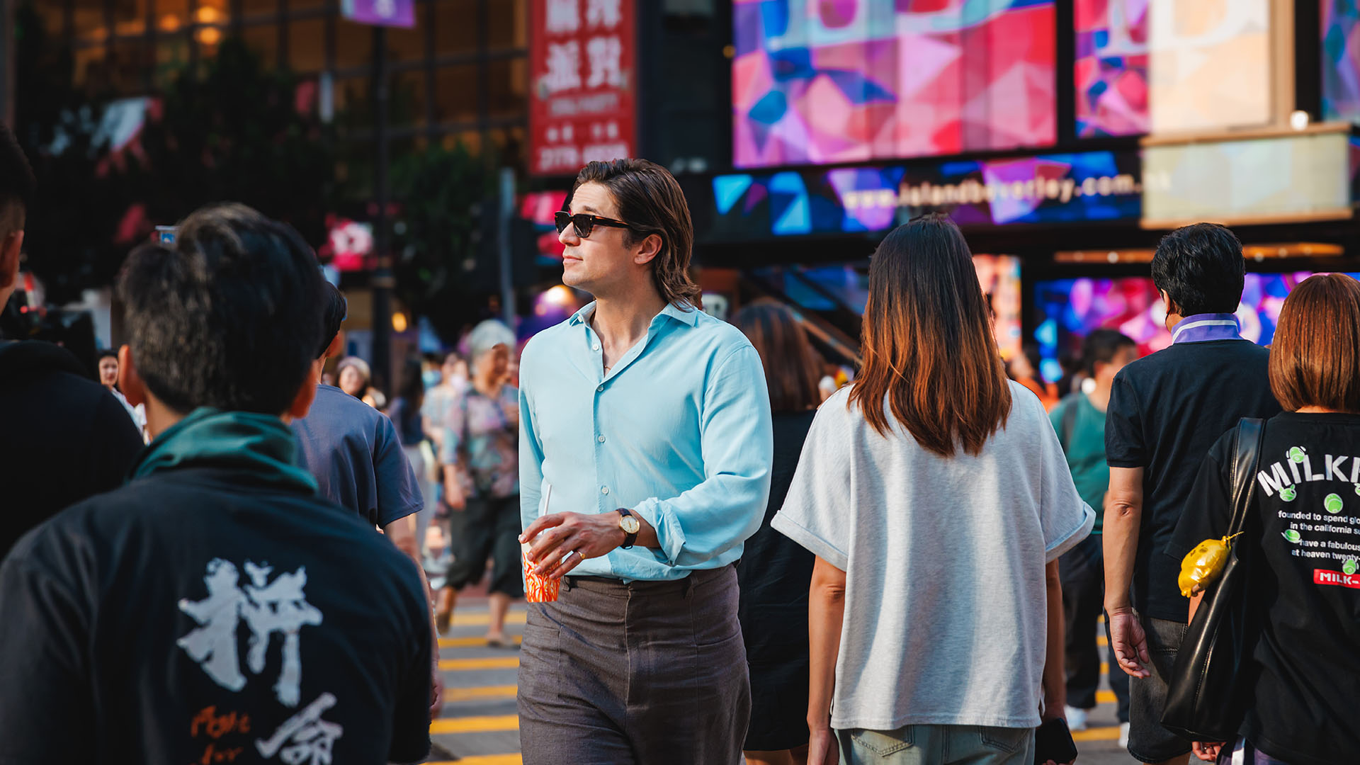 Lucas Bravo walking through the streets of Hong Kong.