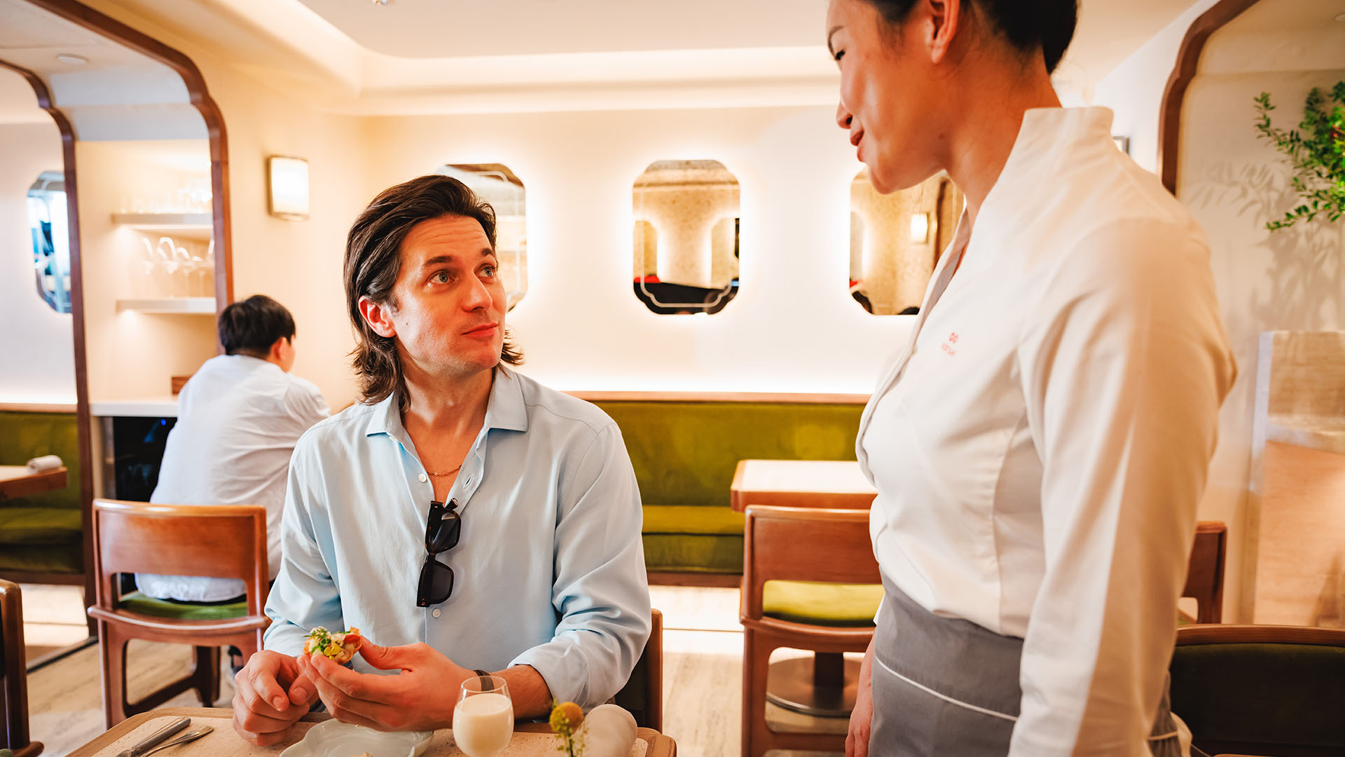 Lucas Bravo enjoying a meal at Michelin restaurant Mora in Hong Kong.
