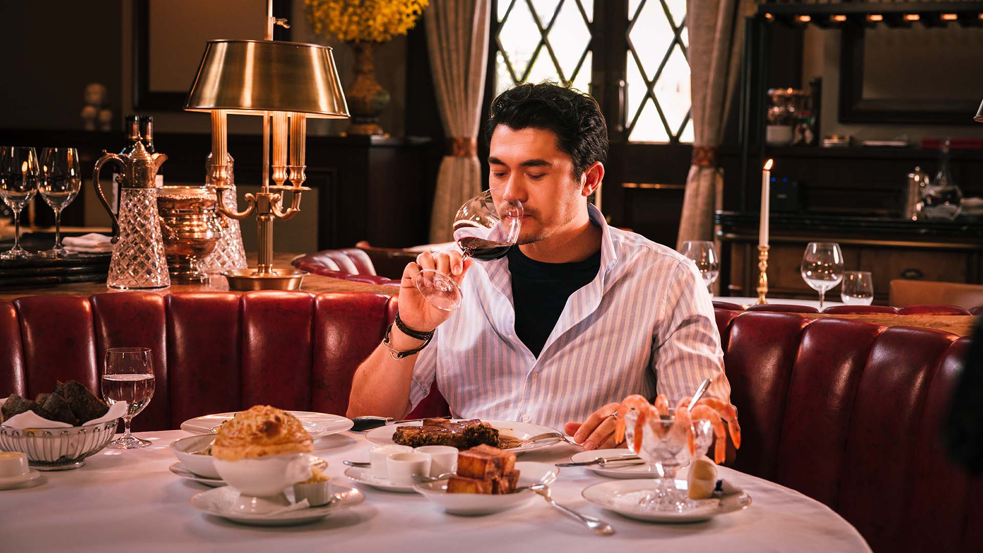 Henry Golding dining in the historical dining room of The Magistracy at Tai Kwun